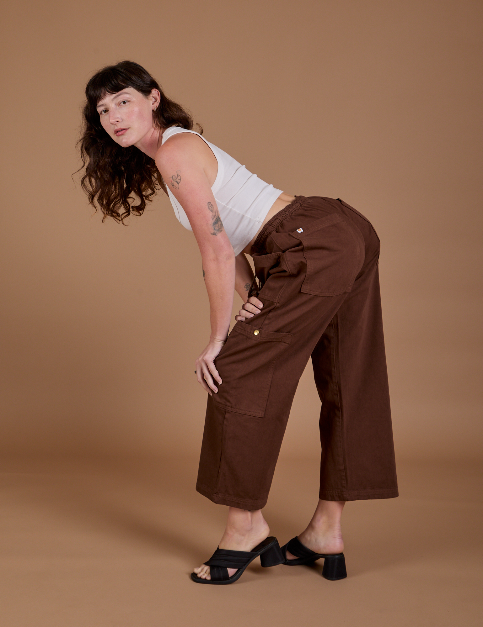 Alex is wearing Drop Pocket Cargo Pants in Fudgesicle Brown and Cropped Tank in vintage tee white