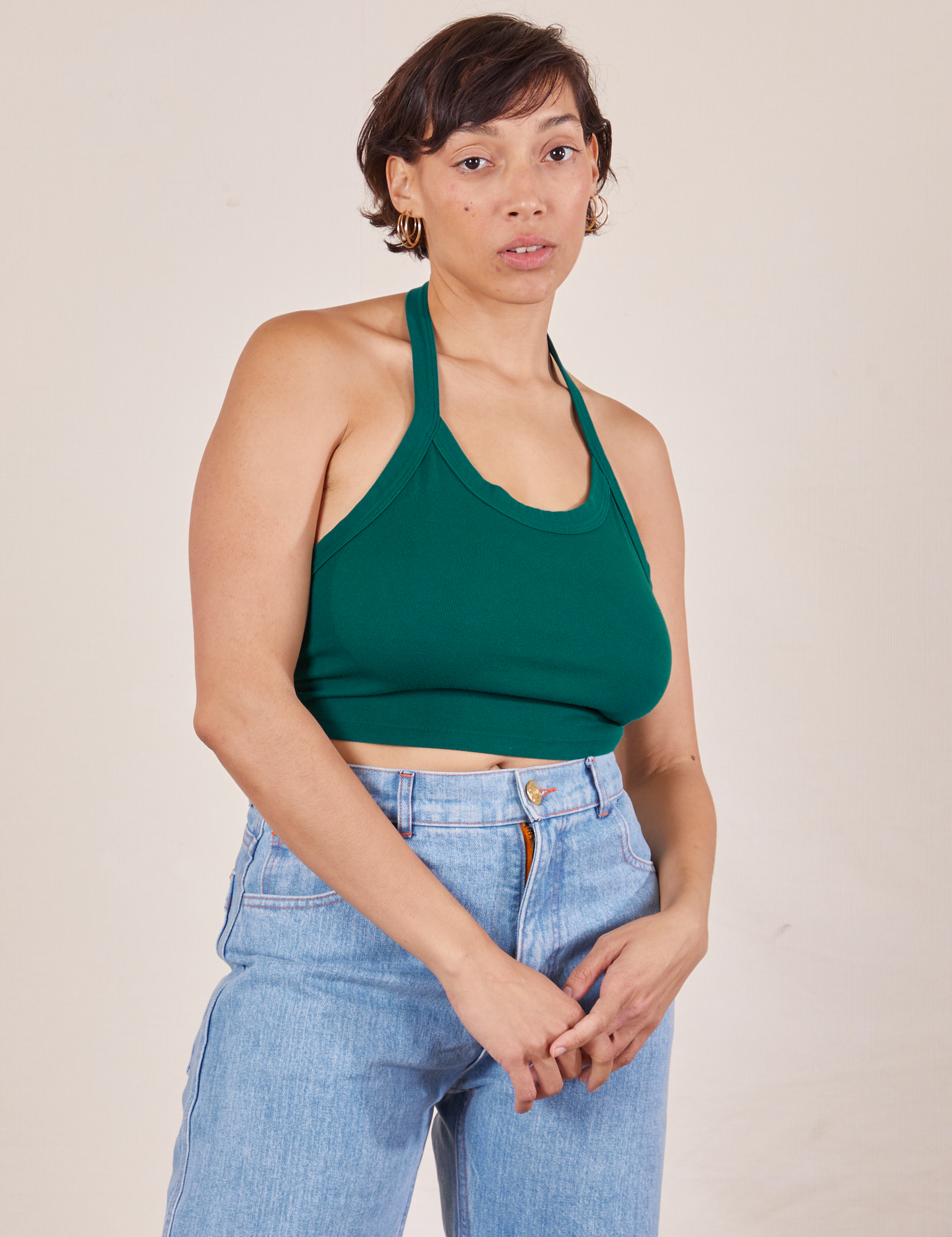 Tiara is 5&#39;4&quot; and wearing XS Halter Top in Hunter Green paired with light wash Sailor Jeans