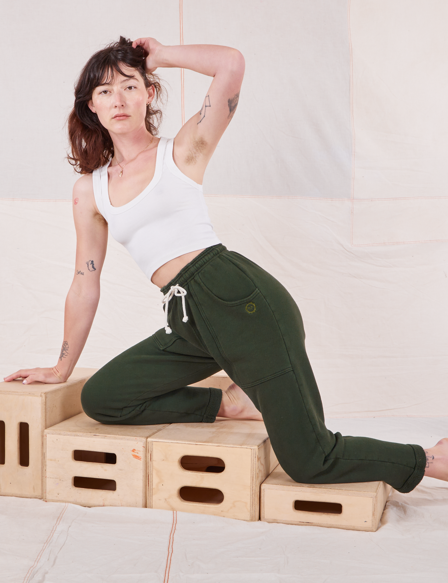 Alex is wearing Rolled Cuff Sweat Pants in Swamp Green and Cropped Tank in vintage tee off-white