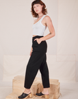 Side view of Heavyweight Trousers in Basic Black and Cropped Tank Top in vintage tee off-white worn by Alex.