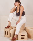 Tiara is sitting on a wooden crate. She is wearing Heavyweight Trousers in Vintage Tee Off-White and espresso brown Cropped Tank Top.