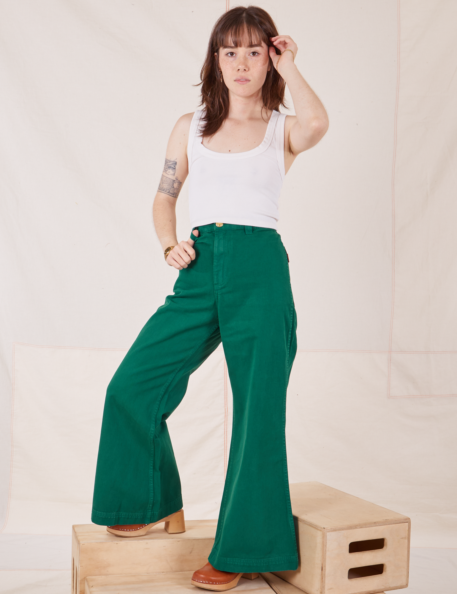 Hana is 5&#39;3&quot; and wearing P Bell Bottoms in Hunter Green paired with vintage off-white Cropped Tank Top