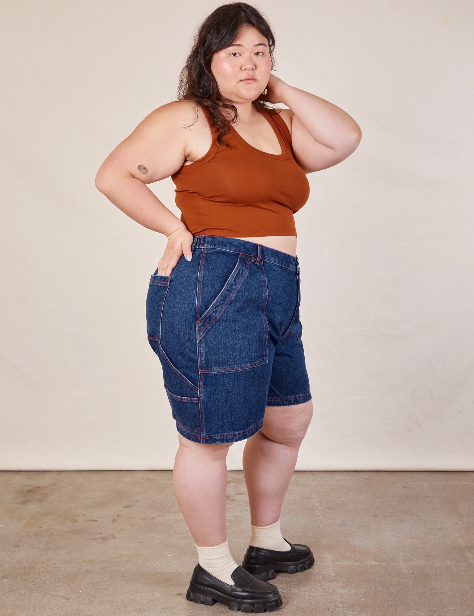 Side view of Carpenter Shorts in Dark Wash and burnt terracotta Cropped Tank on Ashley