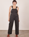 Tiara is 5'4" and wearing size XS Original Overalls in Mono Espresso with a Cropped Tank Top in vintage tee off-white underneath.