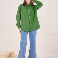 Hana is wearing a buttoned up Oversize Overshirt in Lawn Green paired with light wash Sailor Jeans
