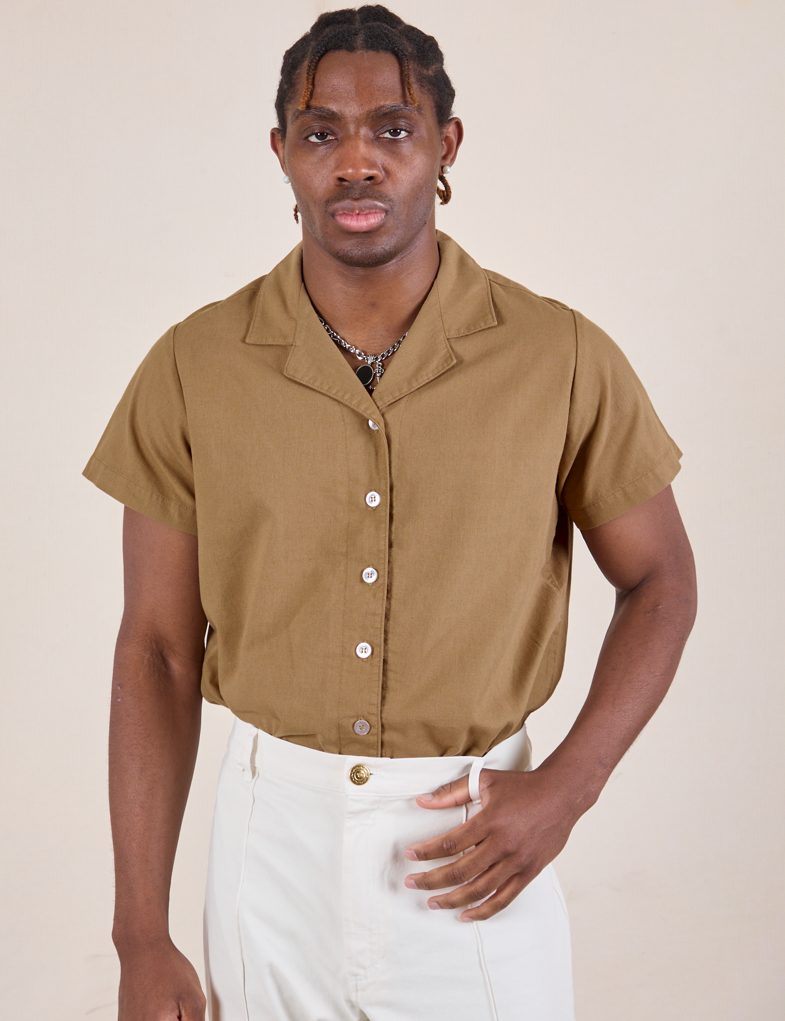 Isaac is wearing Pantry Button-Up in Desert Brown tucked into vintage tee off-white Western Pants