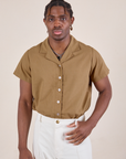 Isaac is wearing Pantry Button-Up in Desert Brown tucked into vintage tee off-white Western Pants