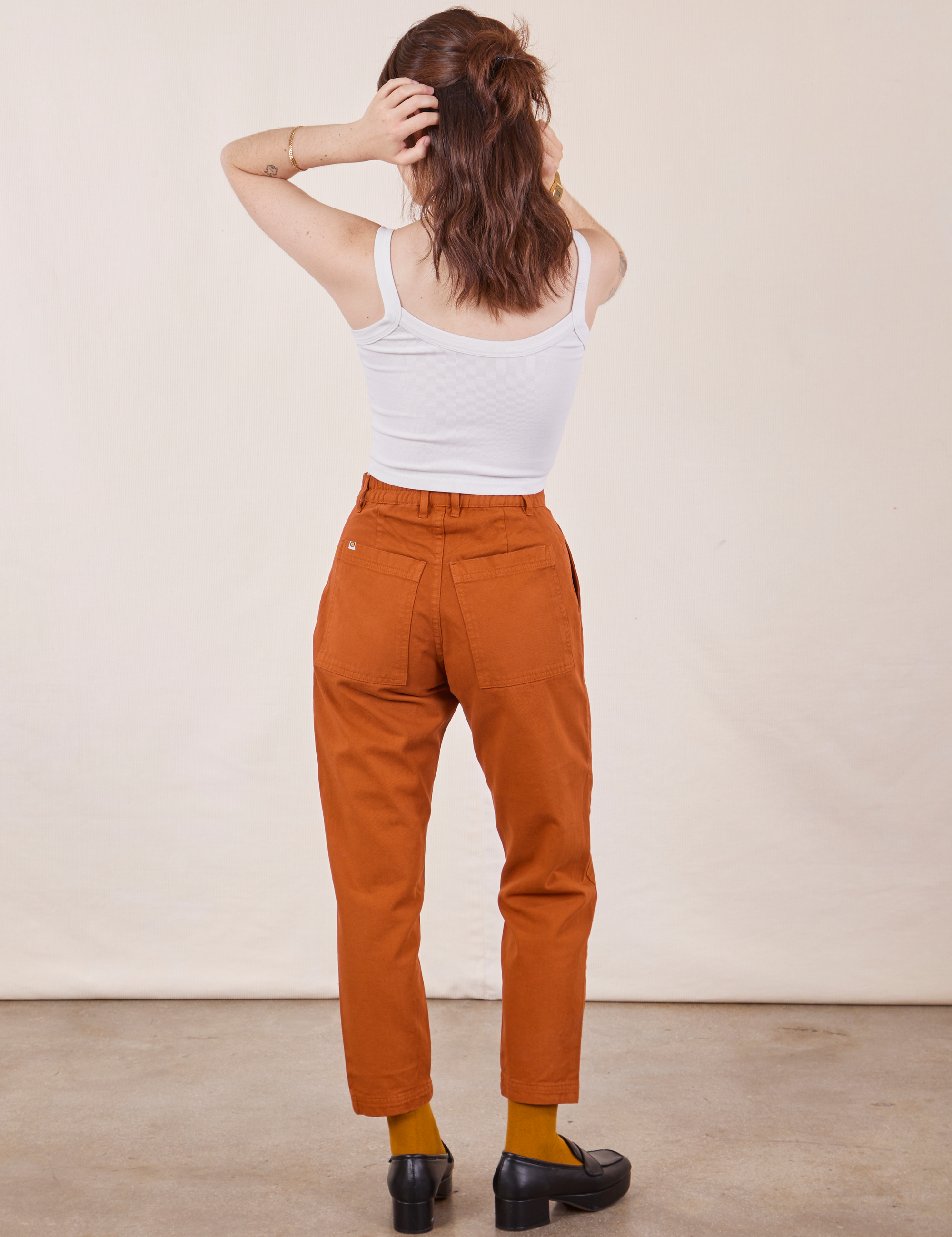 Back view of Petite Pencil Pants in Burnt Terracotta and Cropped Cami in vintage tee off-white on Hana