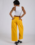 Back view of Drop Pocket Cargo Pants in Sunshine Yellow and Cropped Tank in Vintage Tee White on Kira