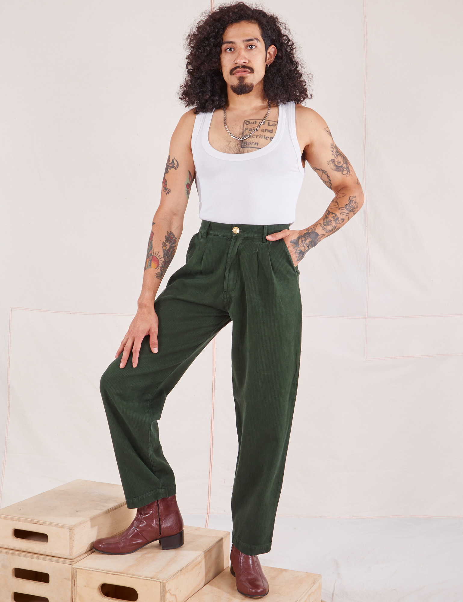 Jesse is 5&#39;8&quot; and wearing XS Heritage Trousers in Swamp Green paired with vintage off-white Cropped Tank Top