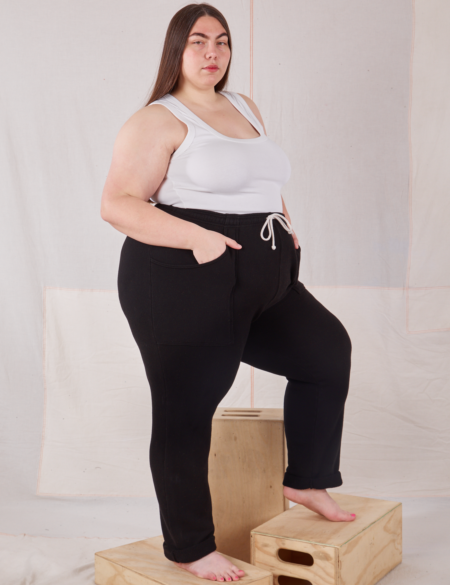 Side view of Rolled Cuff Sweat Pants in Basic Black and vintage off-white Cropped Tank on Marielena
