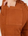 Classic Work Shorts in Burnt Terracotta back pocket close up. Tiara has her hand in the pocket.