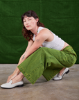 Alex is wearing Overdyed Wide Leg Trousers in Gross Green and Cropped Tank Top in vintage tee off-white