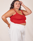Angled side view of Cropped Cami in Mustang Red and vintage off-white Western Pants worn by Alicia