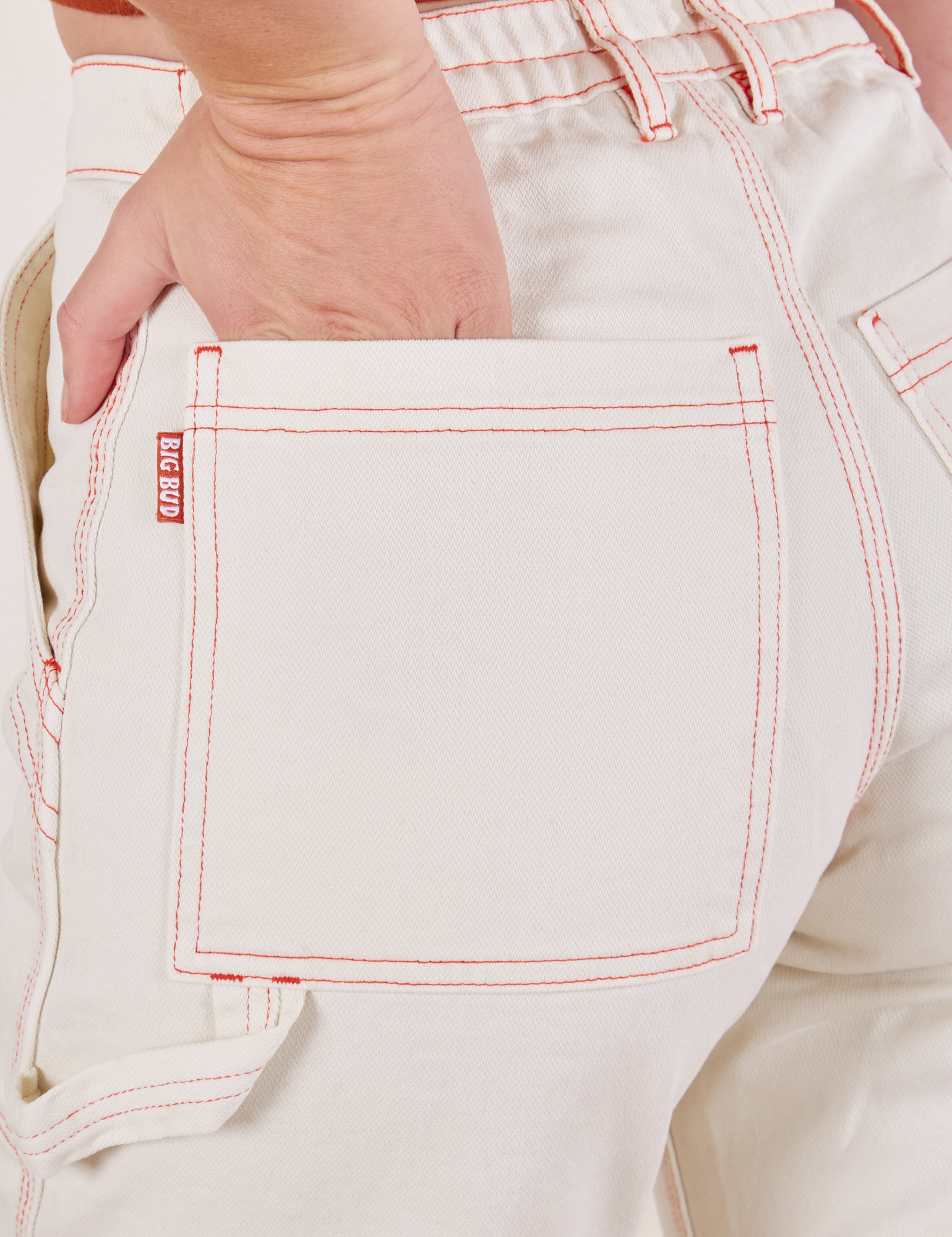 Carpenter Jeans in Vintage Off-White back pocket close up. Alex has her hand in the pocket.