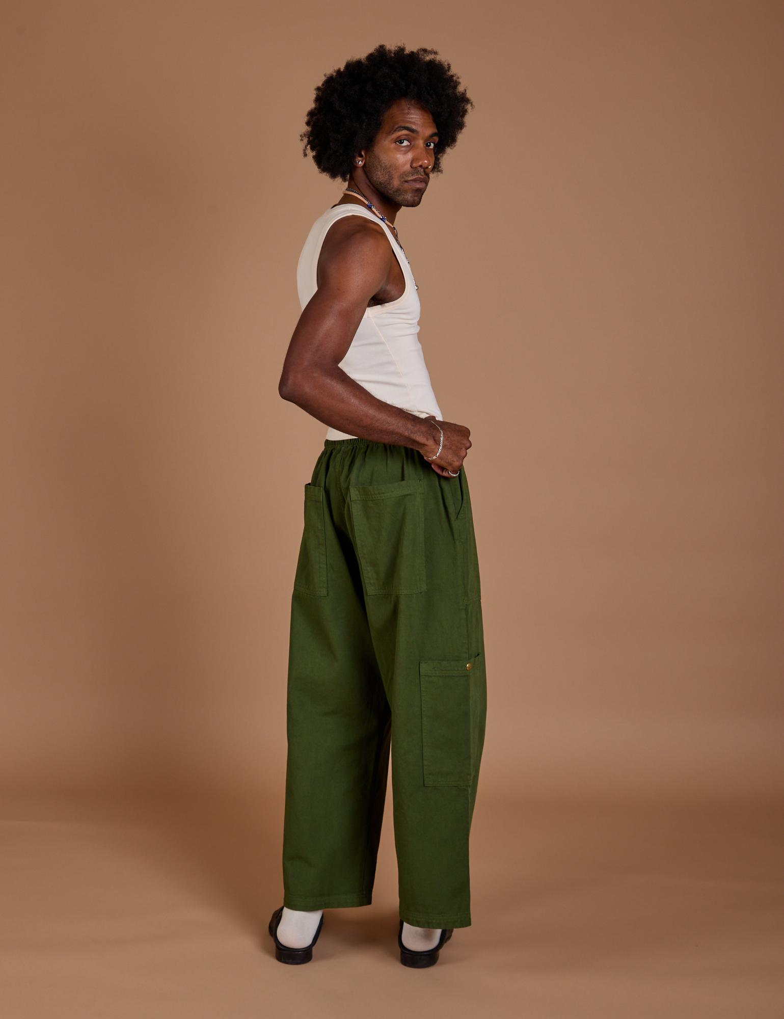 Angled back view of Drop Pocket Cargo Pants in Evergreen on Jerrod