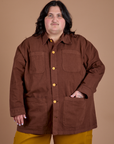 Sam is wearing a buttoned up Ripstop Field Coat in Fudgesicle Brown
