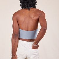 Back view of Halter Top in Periwinkle and vintage off-white Western Pants worn by Jerrod. They have their left hand in the pant back pocket.