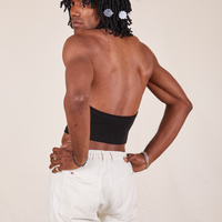 Angled back view of Halter Top in Basic Black and vintage off-white Western Pants worn by Jerrod