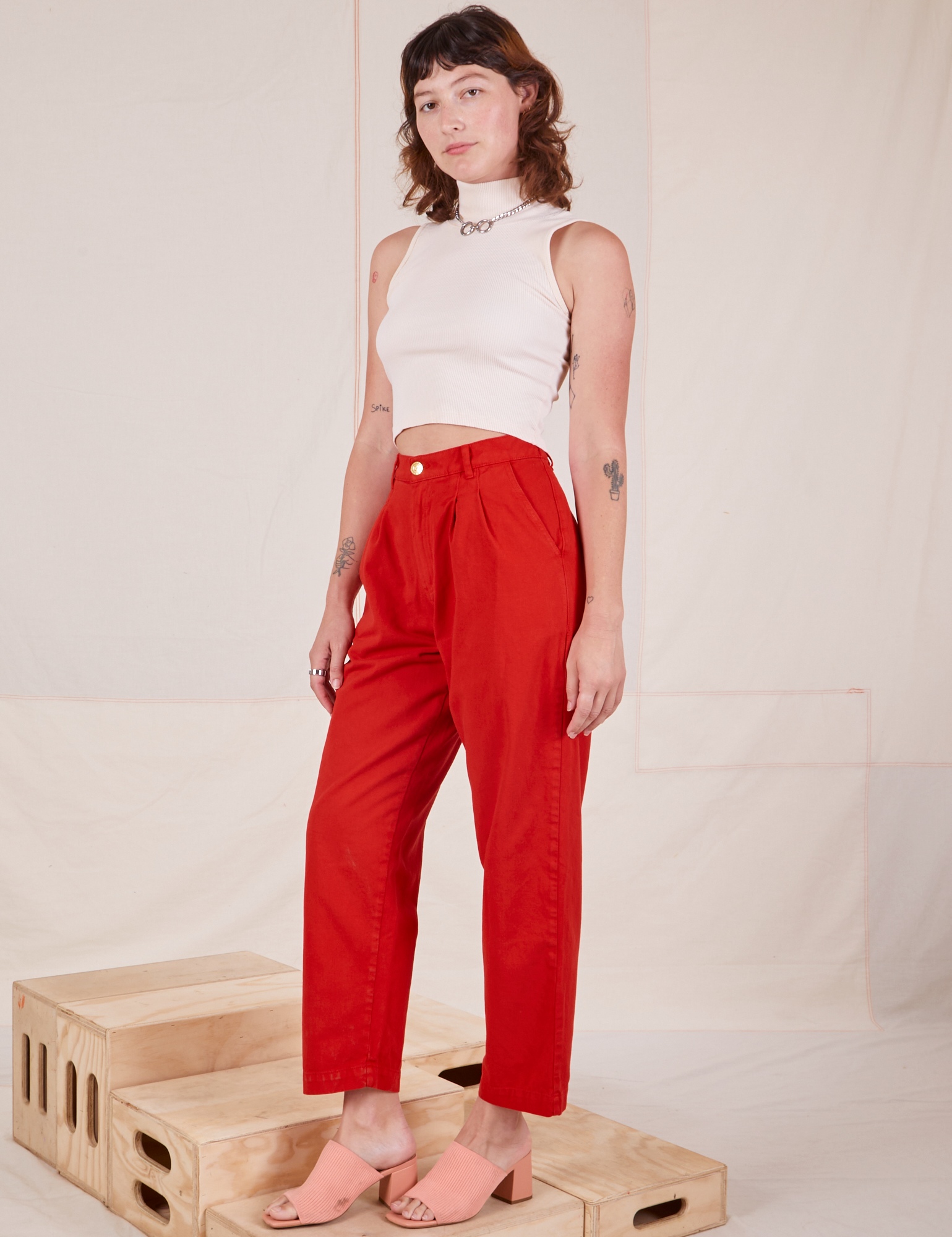 Alex is 5'8" and wearing XXS Heavyweight Trousers in Mustang Red paired with Sleeveless Turtleneck in vintage tee off-white