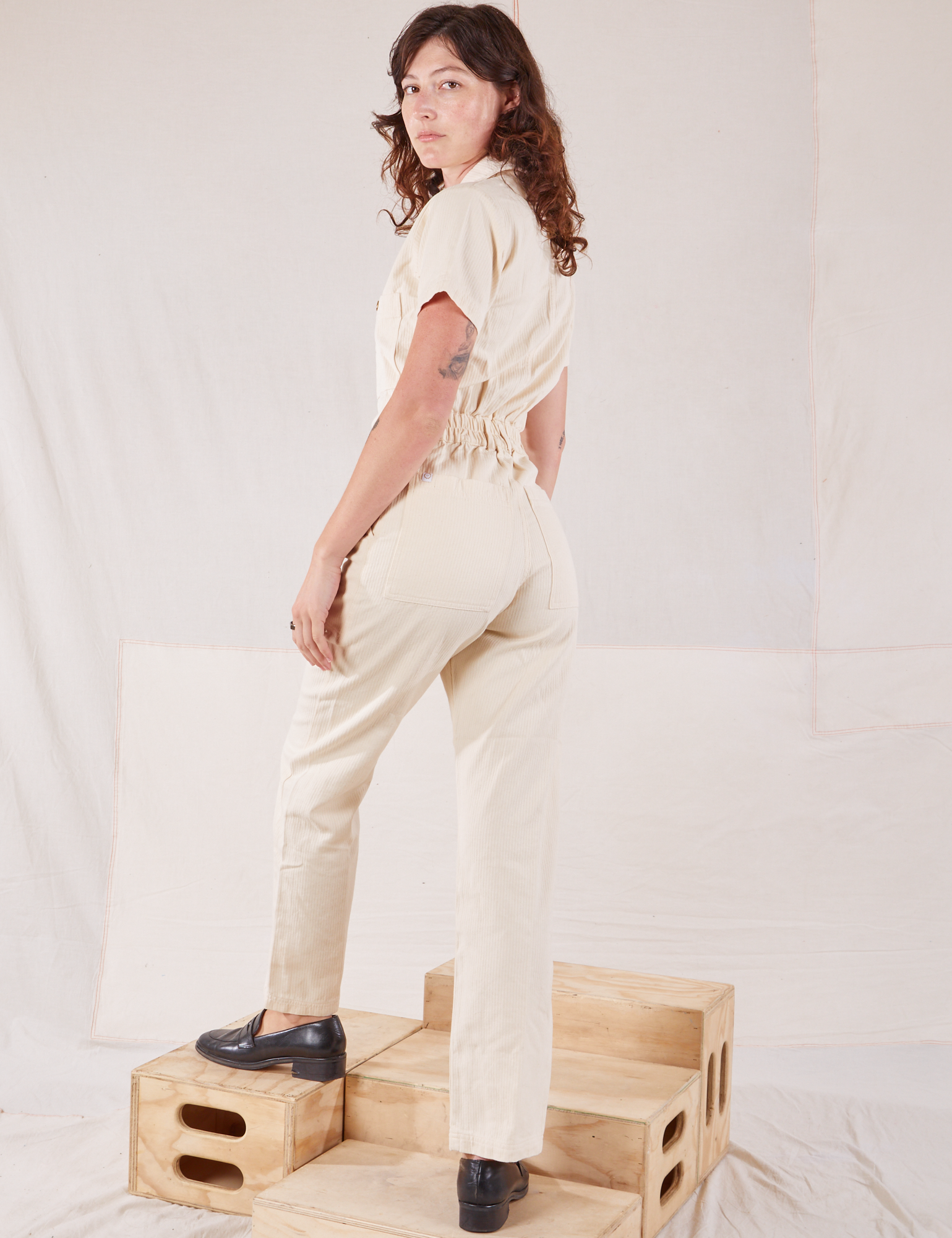 Heritage Short Sleeve Jumpsuit in Natural angled back view on Alex