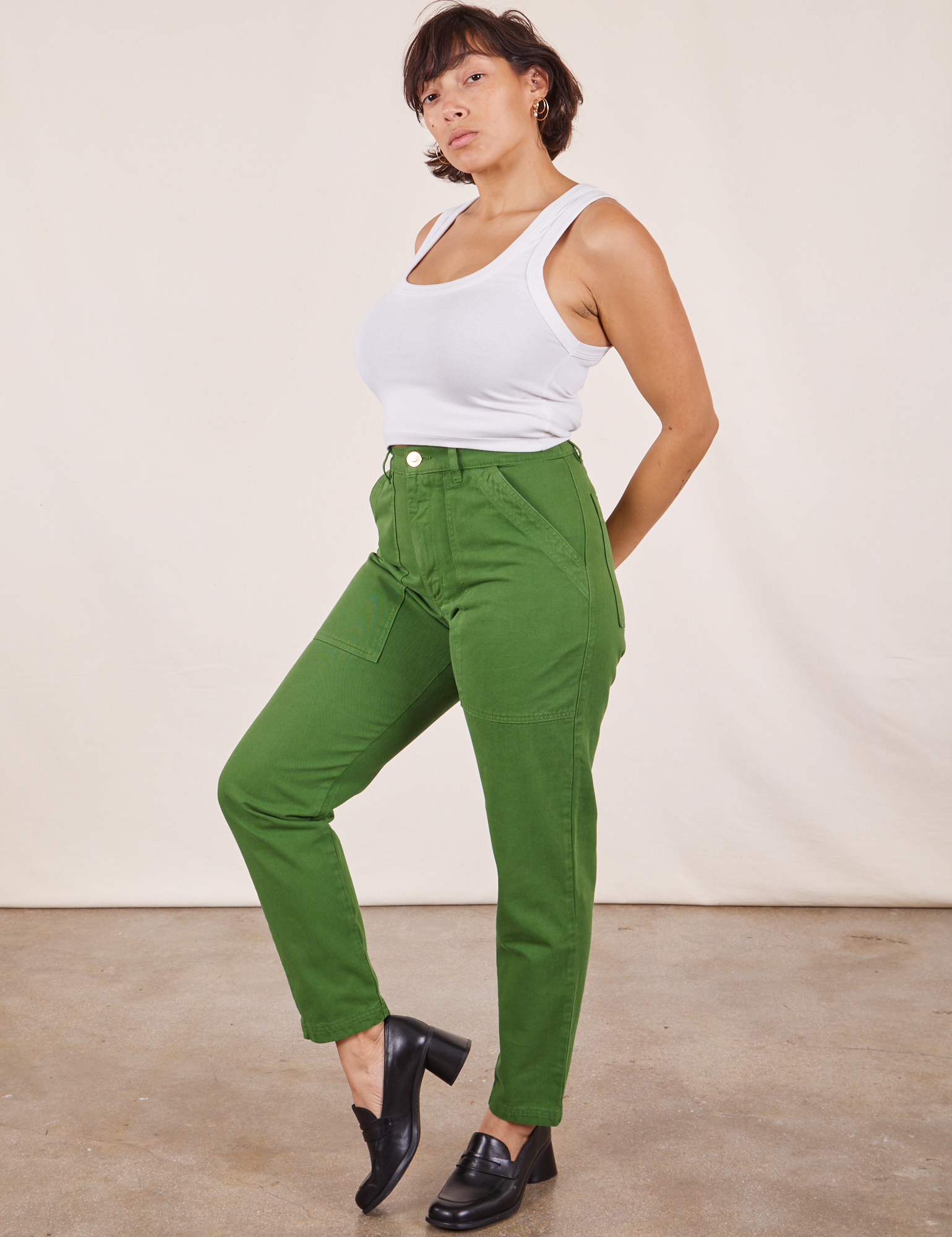 Angled view of Pencil Pants in Lawn Green and vintage off-white Cropped Tank Top worn by Tiara