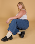 Juliet is sitting on the floor and wearing Baggy Mid-Rise Trousers in French Blue