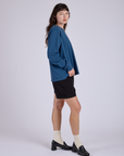 Side view of Pleated Trouser Shorts in Basic Black and Long Sleeve Burly Tee in French Blue