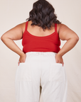 Back view of Cropped Cami in Mustang Red and vintage off-white Western Pants worn by Alicia. She has both hands in the back pant pocket.