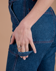 Alex has her fingers through the hammer loop on the Carpenter Jeans in Dark Wash
