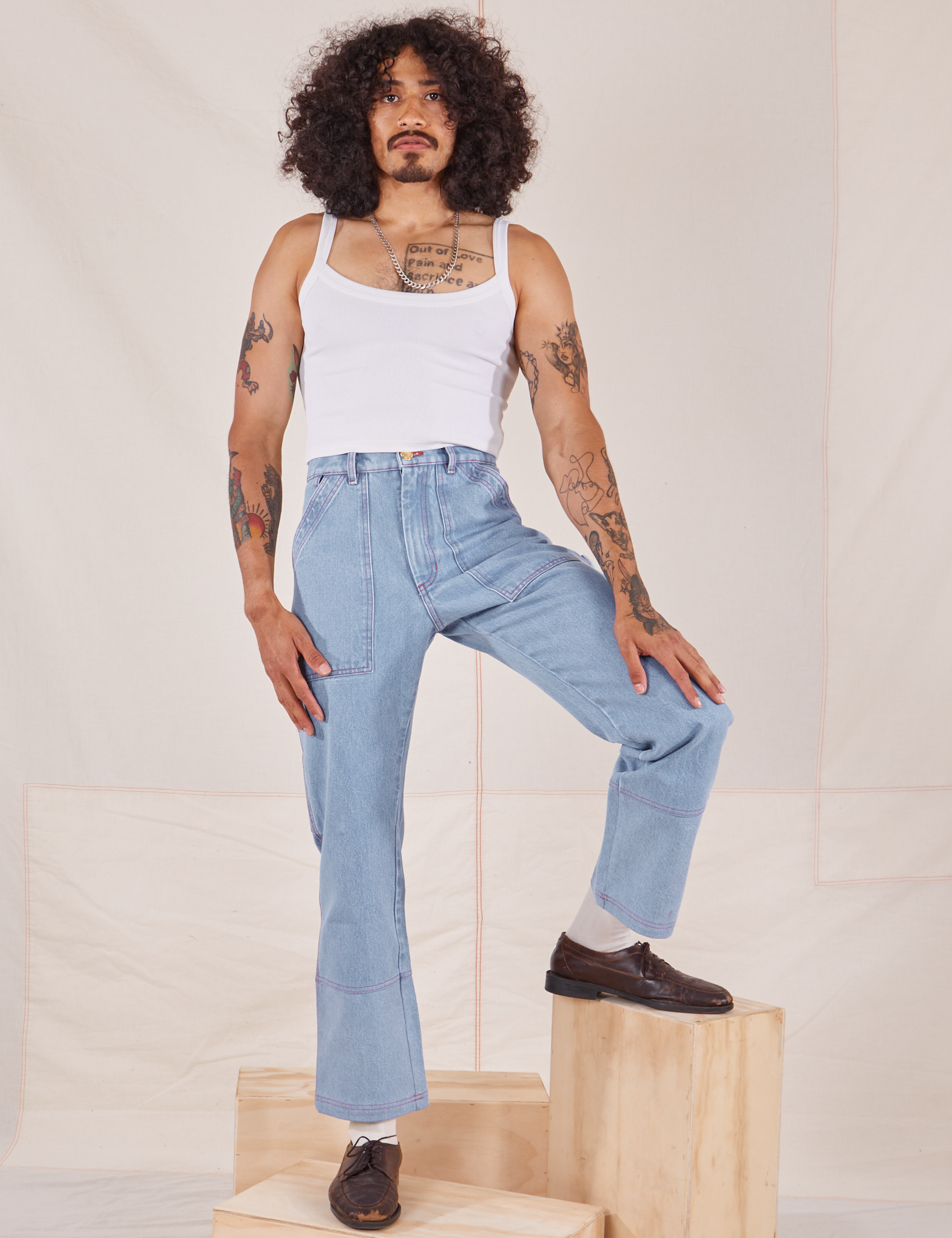 Jesse is 5&#39;8&quot; and wearing XS Carpenter Jeans in Light Wash paired with a vintage off-white Cami