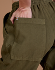 Close up of Alex's hand in the back pocket of Drop Pocket Cargo Pants in Surplus Green