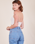 Angled back view of Halter Top in Vintage Tee Off-White and light wash Frontier Jeans worn by Alex