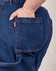 Carpenter Shorts in Dark Wash back pocket close up. Ashley has her hand in the pocket.