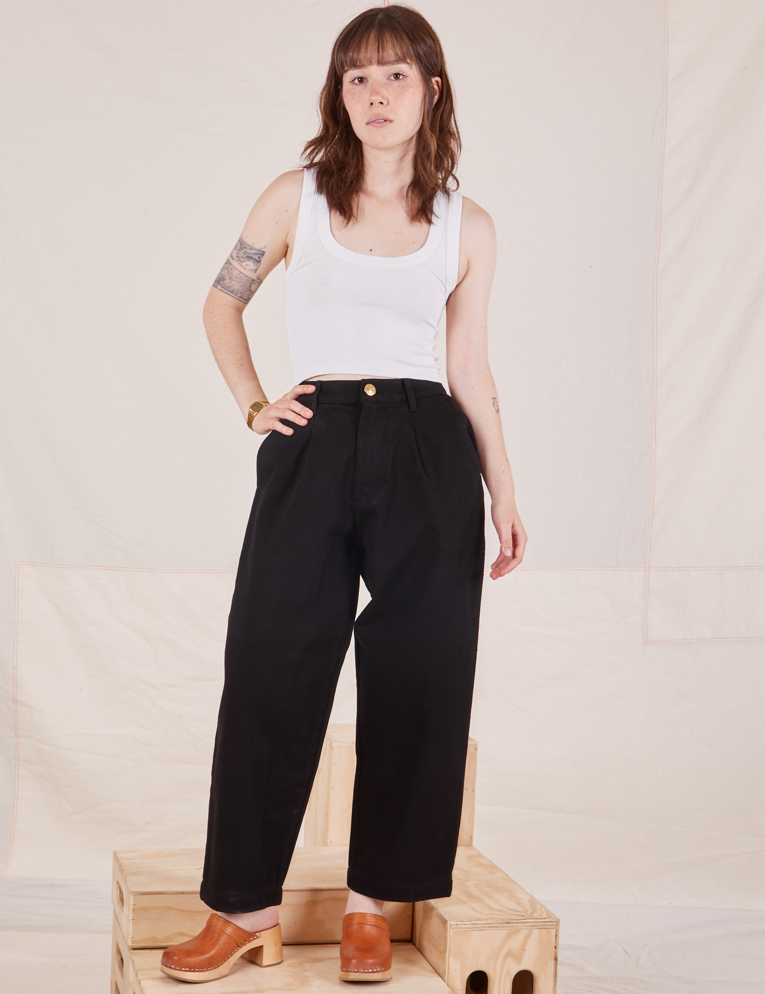 Hana is 5&#39;3&quot; and wearing XXS Petite Denim Trouser Jeans in Black paired with Cropped Tank Top in vintage tee off-white