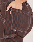 Railroad Carpenter Jeans in Fudgesicle Brown back pocket close up. Tiara has her hand in the pocket.