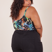Angled back view of Cropped Cami in Rainbow Magic Waters and black Western Pants worn by Morgan