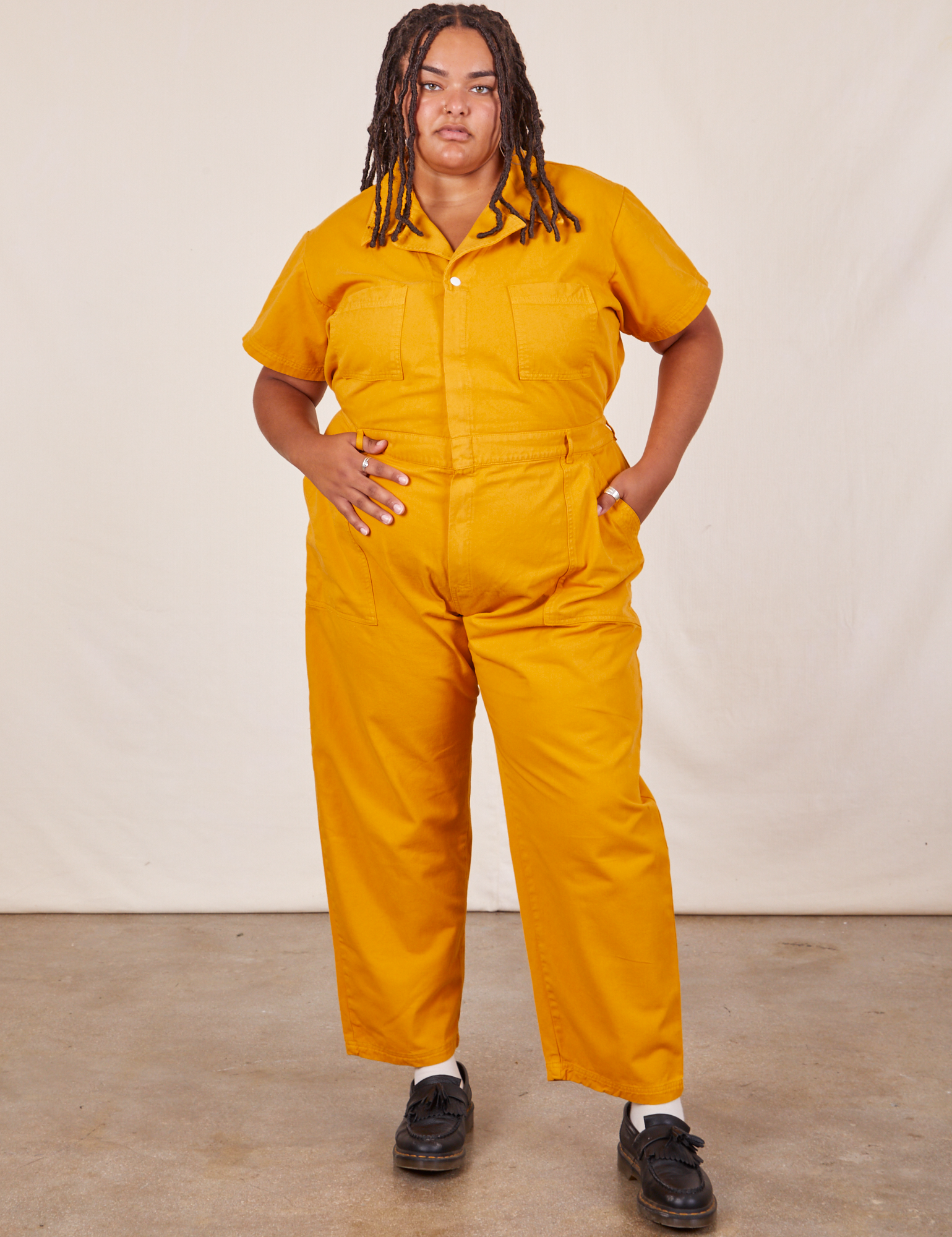 Alicia is 5’9” and wearing 2XLShort Sleeve Jumpsuit in Mustard Yellow