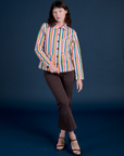 Alex is wearing a buttoned up Stripe Work Jacket in Rainbow Stripe paired with espresso brown Work Pants
