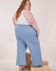 Angled back view of Indigo Wide Leg Trousers in Light Wash and vintage off-white Cami on Catie