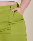 Close up of Ashley's hand in the front pocket of Work Pants in Gross Green