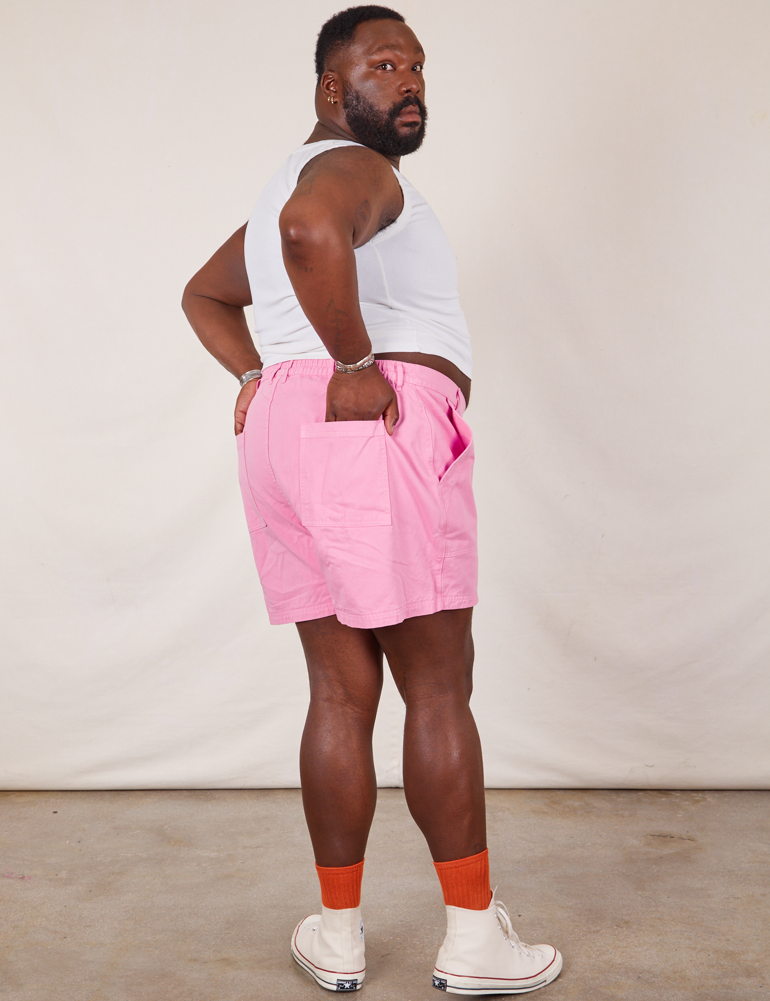 Angled back view of Classic Work Shorts in Bubblegum Pink and Cropped Tank Top in vintage tee off-white on Elijah