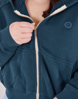 Cropped Zip Hoodie in Lagoon front close up. Ashley is pulling the zipper up.