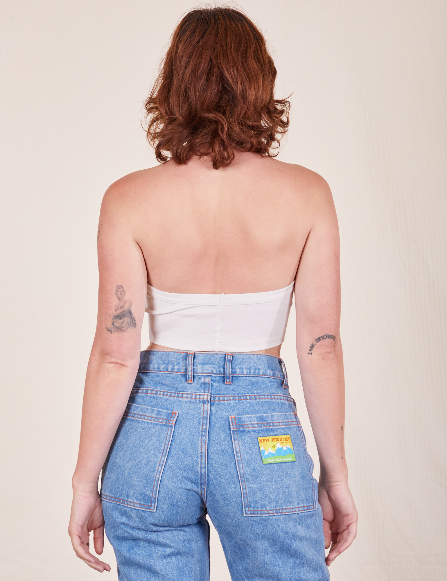 Back view of Halter Top in Vintage Tee Off-White and light wash Frontier Jeans worn by Alex