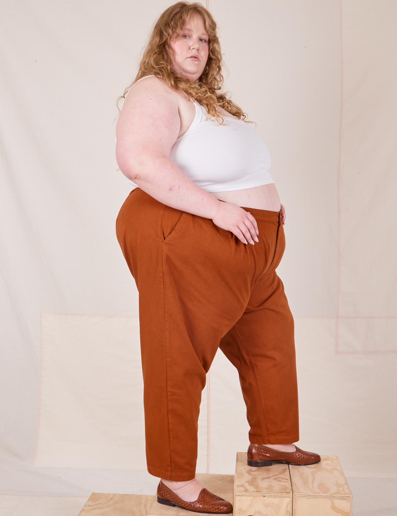 Side view of Heavyweight Trousers in Burnt Terracotta and Cropped Cami in vintage tee off-white worn by Catie