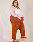 Side view of Heavyweight Trousers in Burnt Terracotta and Cropped Cami in vintage tee off-white worn by Catie