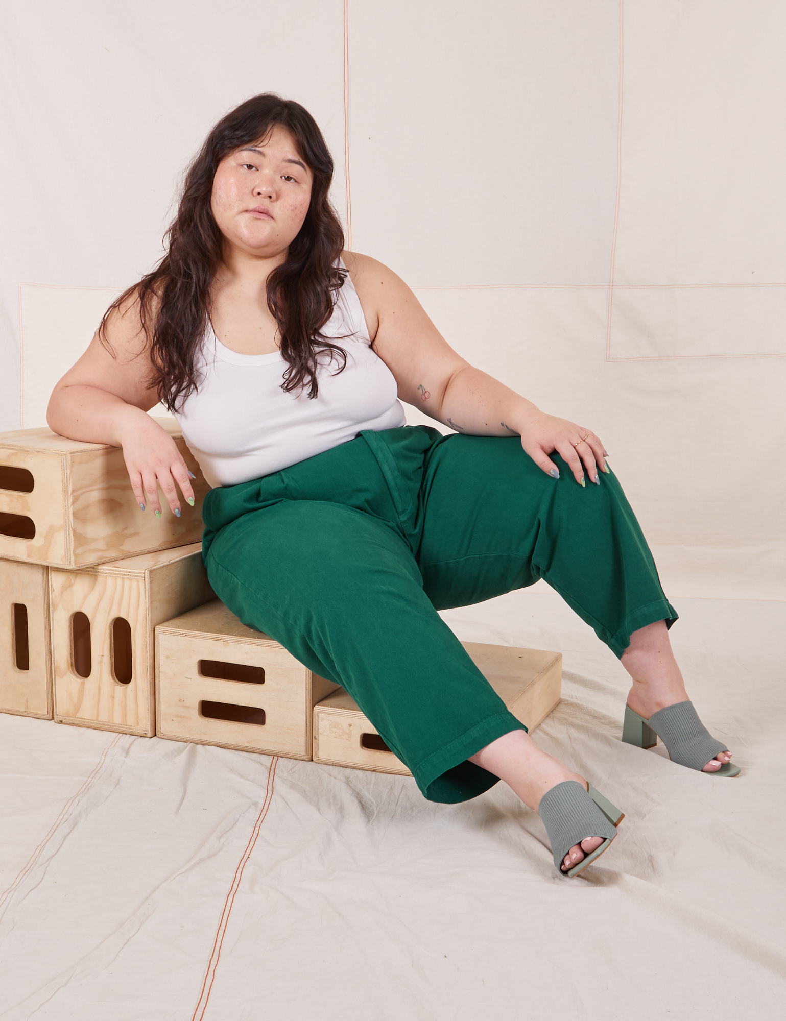 Ashley is wearing Heavyweight Trousers in Hunter Green and Cropped Tank Top in vintage tee off-white