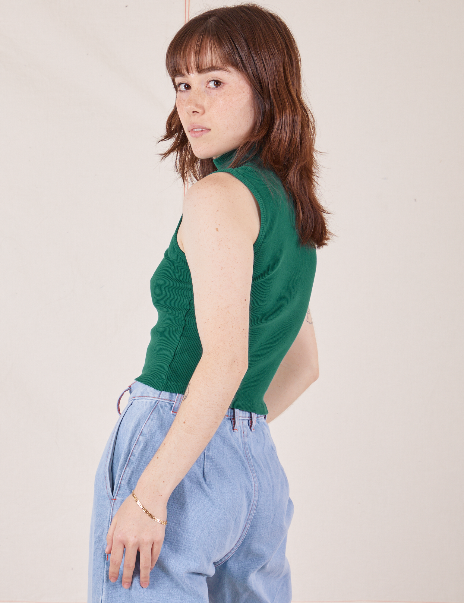 Angled back view of Sleeveless Essential Turtleneck in Hunter Green on Hana