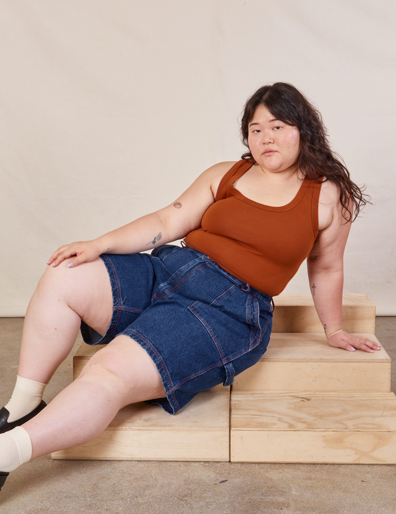 Ashley is wearing Carpenter Shorts in Dark Wash and burnt terracotta Cropped Tank