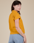 Angled back view of Pantry Button-Up in Mustard Yellow on Alex